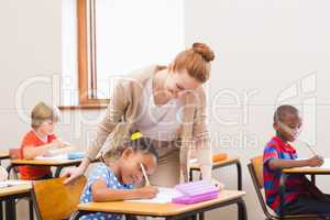 Teacher helping pupil in classroom