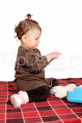 Baby girl sitting on blanket.