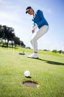 Female golfer putting her ball