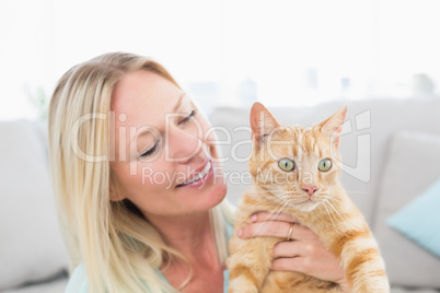 Young woman holding cat at home