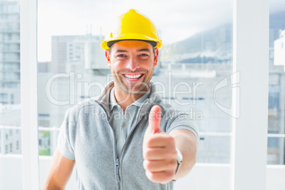 Manual worker gesturing thumbs up in building