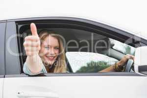 Happy woman sitting in drivers seat thumb up