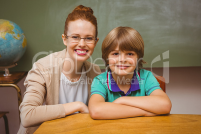 Happy female teacher and little boy in classroom