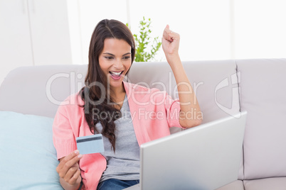 Woman shopping online through laptop using credit card