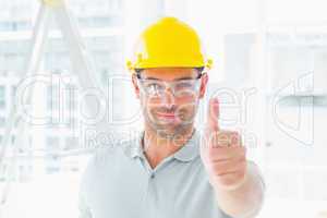 Manual worker gesturing thumbs up at site