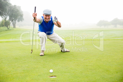 Happy golfer cheering on putting green