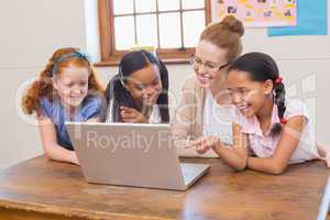 Teacher and pupils looking at laptop