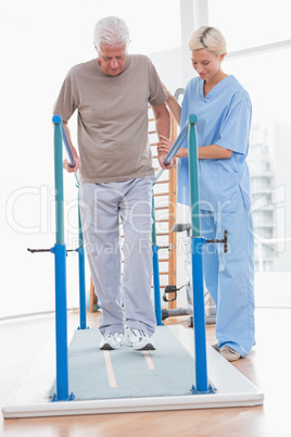 Senior man walking with therapist help