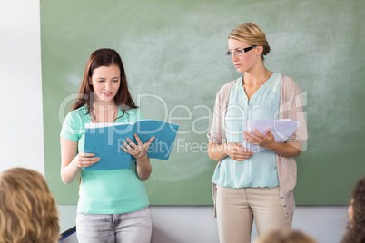 Student explaining notes besides teacher in class