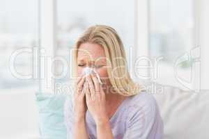 Woman sneezing in tissue