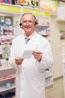Smiling senior pharmacist with headphone