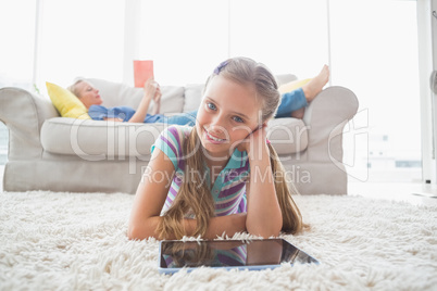 Portrait of happy girl using digital tablet on rug at home Portrait of happy girl using digital tablet on rug at home