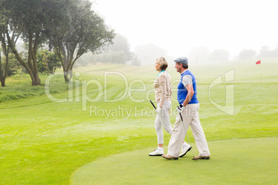 Golfing couple walking on the putting green