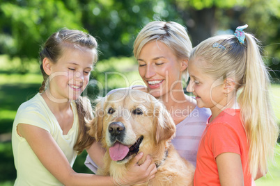 Happy family playing with their dog