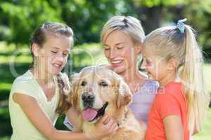 Happy family playing with their dog