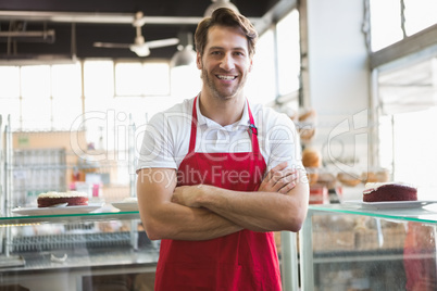 Portrait of happy server with arms crossed