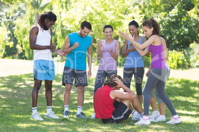 Fitness group encouraging man doing sit ups