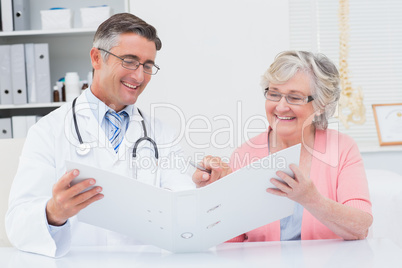 Doctor and female patient looking at reports in file