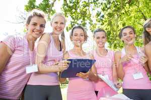 Smiling women organising event for breast cancer awareness