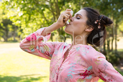 Pretty brunette using her inhaler