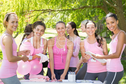 Smiling women organising event for breast cancer awareness