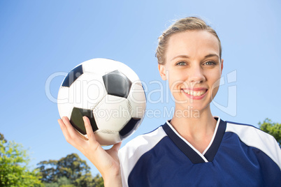 Pretty football player smiling at camera