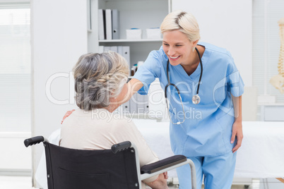 Nurse consoling patient sitting on wheelchair