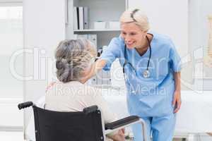 Nurse consoling patient sitting on wheelchair