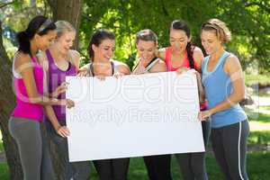 Fitness group holding poster in park