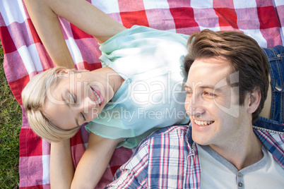 Happy couple lying together at the park