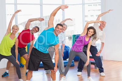 People doing stretching exercise in gym