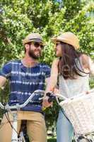 Hipster couple on a bike ride in the park