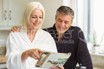 Mature couple reading magazine together in morning