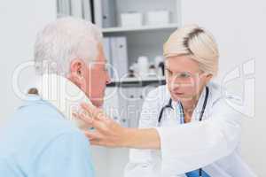 Female doctor examining patient wearing neck brace