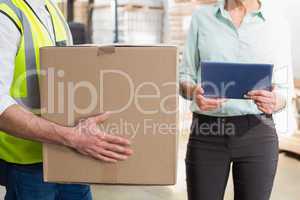 Worker carrying box with manager holding tablet pc