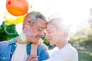 Cute couple holding balloons at the park