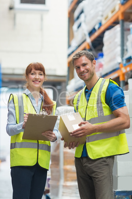 Smiling warehouse manager and delivery man