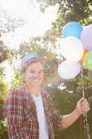Handsome hipster holding balloons