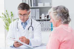 Doctor explaining prescriptions to senior woman