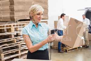 Smiling warehouse manager scanning package