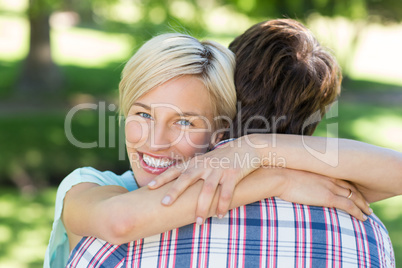 Happy couple hugging at the park