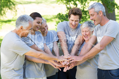 Happy volunteer family putting their hands together