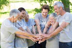 Happy volunteer family putting their hands together