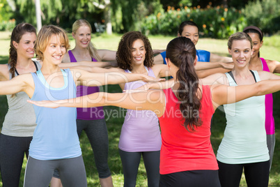 Fitness group squatting in park