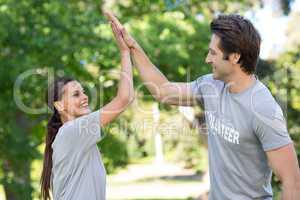 Happy volunteer couple high fiving