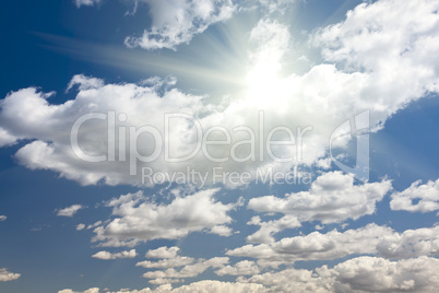 Deep Blue Sky and Puffy Clouds With Sun Rays