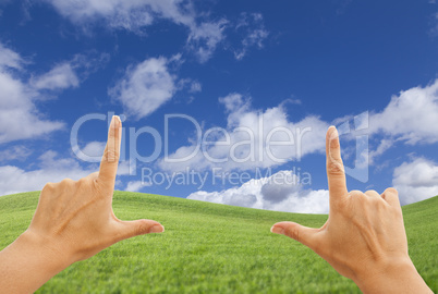 Female Hands Framing Deep Blue Sky Above Grass Field