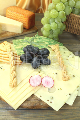 gesunde Käsescheiben mit Weintrauben und Radieschen