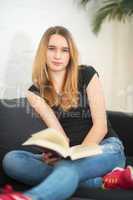 Teenager liest auf dem Sofa ein Buch
