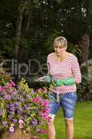 Blond woman pruning or picking flowers